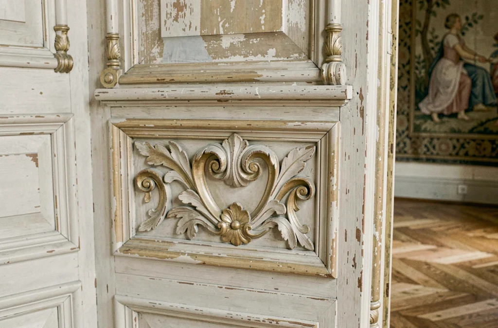 Détail d'un panneau de boiserie ancienne sculptée avec motifs d'acanthe et moulures classiques